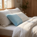 Cooling gel memory foam pillow on a made bed in morning light